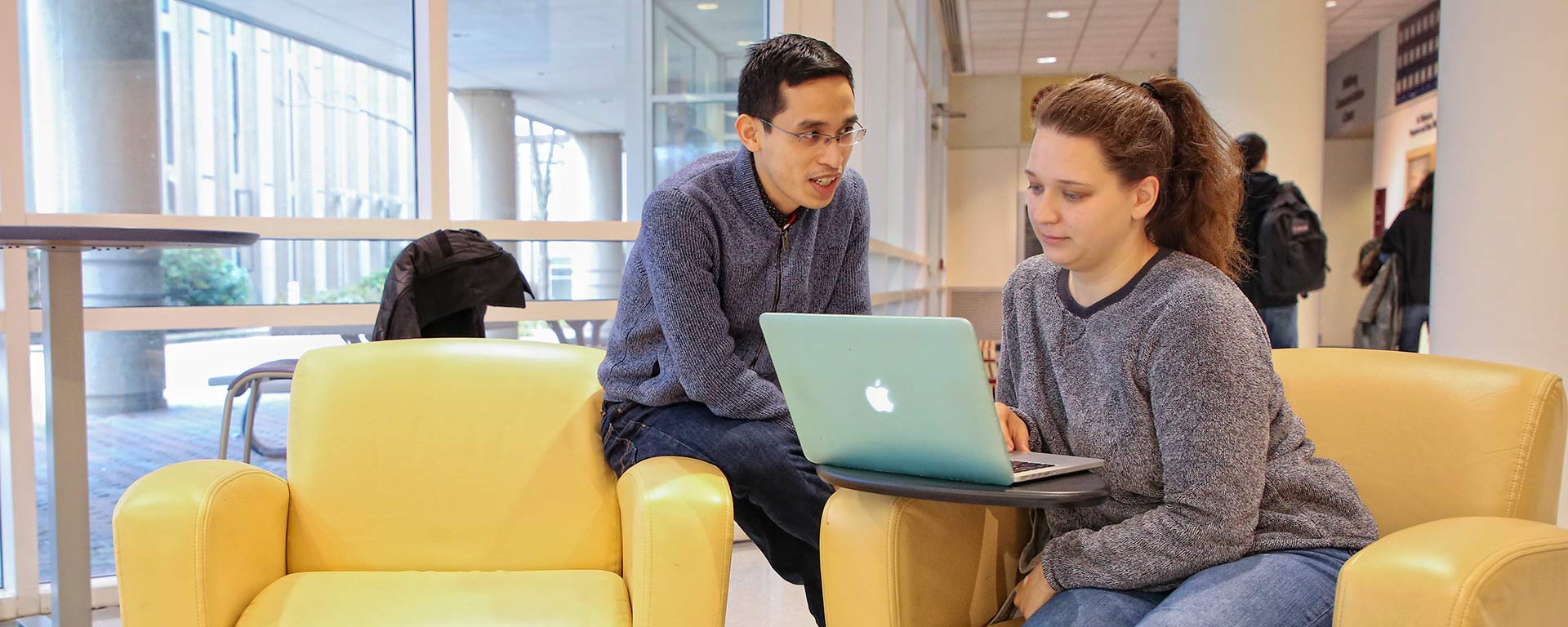 Students talking and looking at a laptop