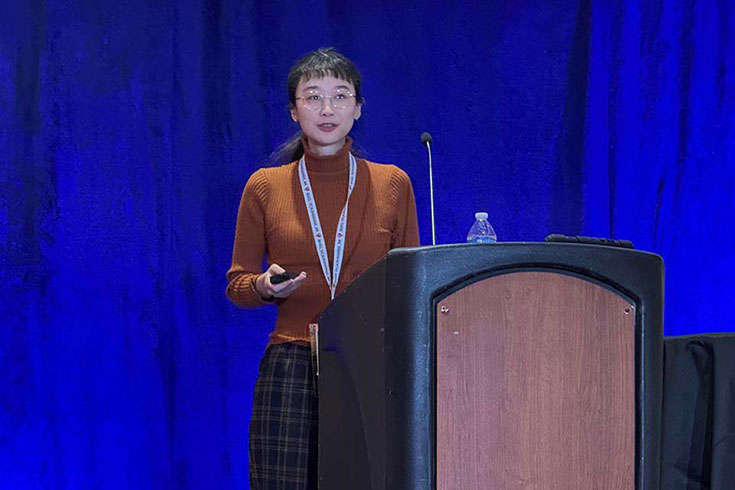 Jin Zhao giving a presentation at a podium