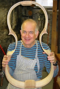 Harry Mairson holding part of a wooden viola 