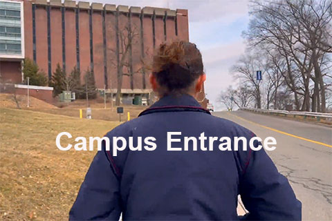 A student walking on campus with the text: Campus entrance