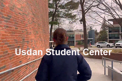 A student walking on campus with text that reads: Usdan Student Center