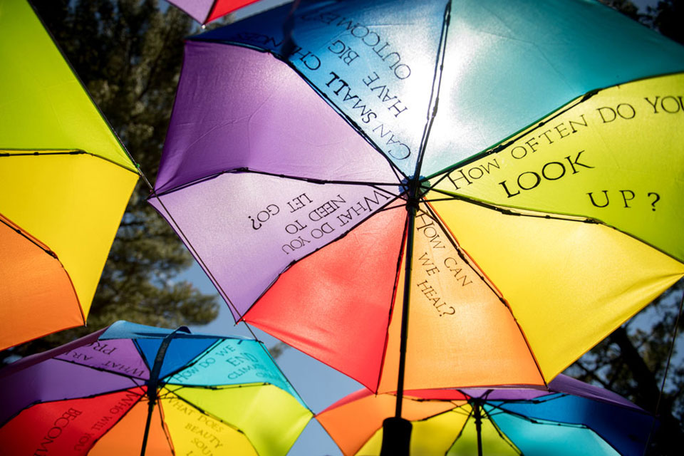 The underside of rainbow umbrellas with the words "How often do you look up?"