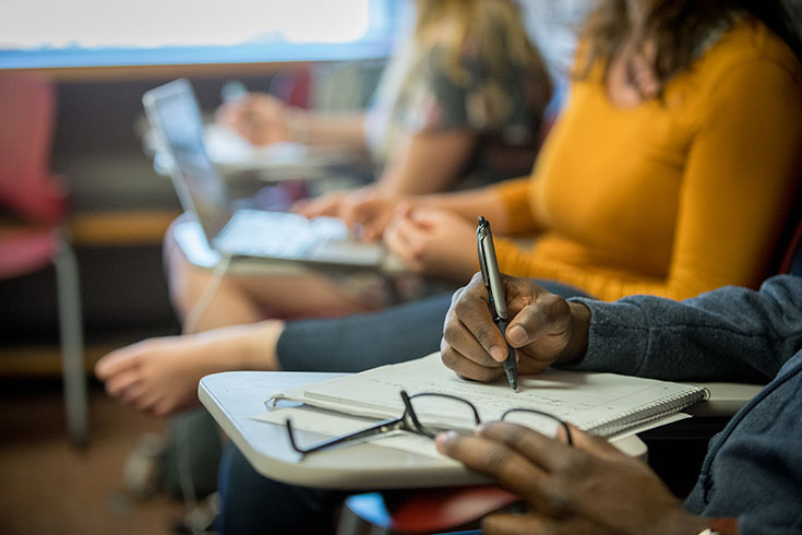 A student writing on a notepad