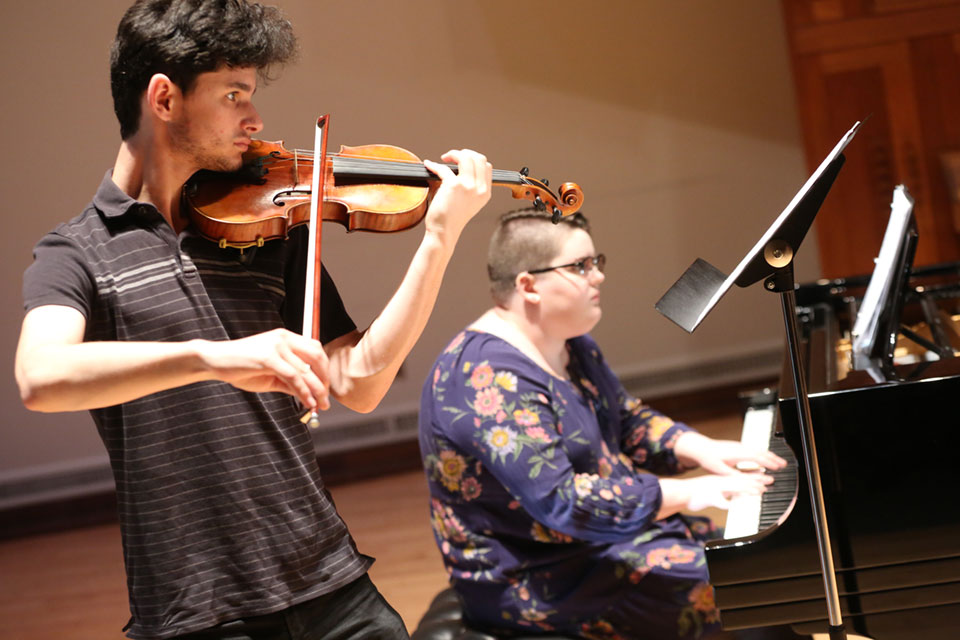 A violinist and pianist on stage