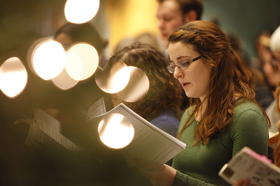 A student singing from a song book