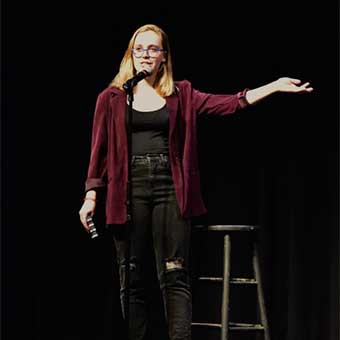 woman standing on stage at mic