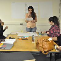 student standing in front of class reading