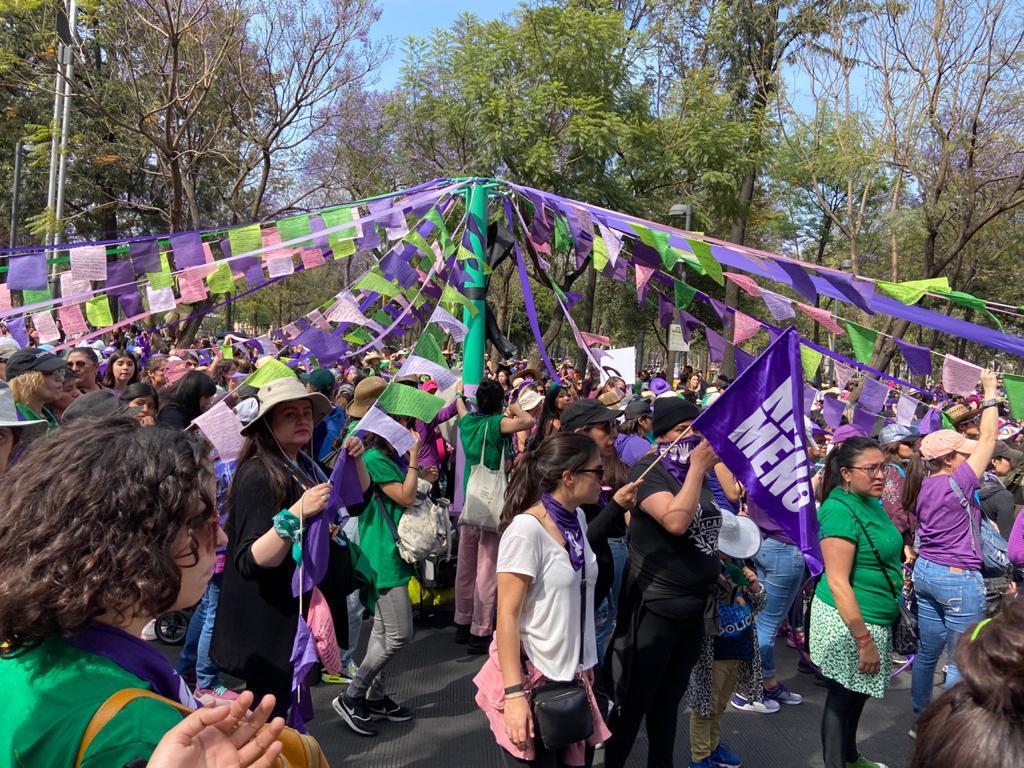 protesters around a maypole with flags and signs