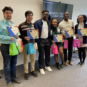 graduates posing with their certificates