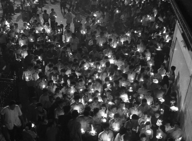 crowd of people holding lights, photographed from overhead