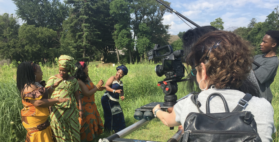 women dancing in a field and being filmed