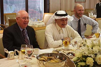 Shai Feldman and Pascal Menomet sit at a dinner table with a man wearing a keffiyeh