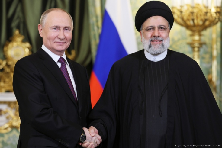 Russian President Vladimir Putin, left, and Iranian President Ebrahim Raisi shake hands