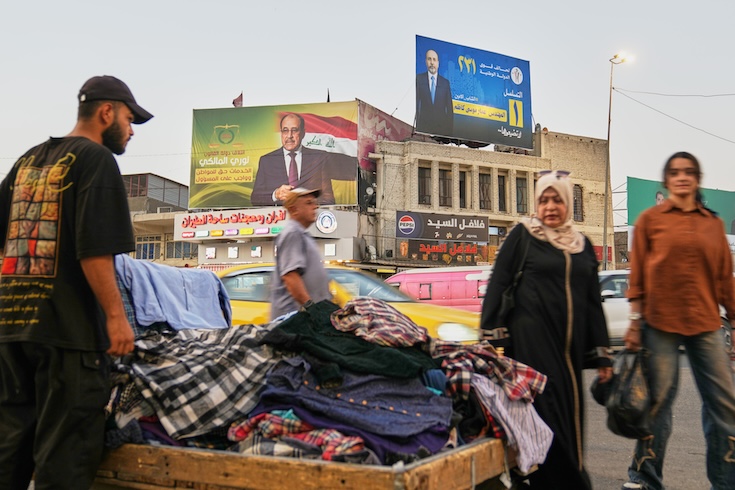 A street vendor works in front of election campaign signs in Baghdad, Iraq.