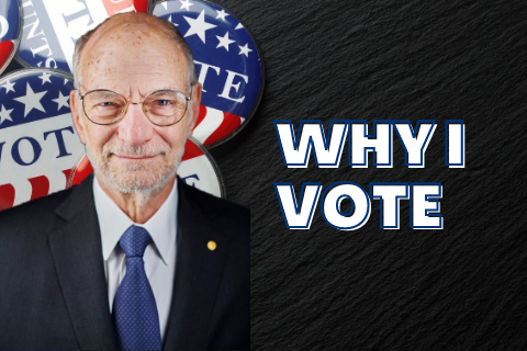 Michael Rosbash standing next to the words Why I Vote with VOTE buttons  in the background
