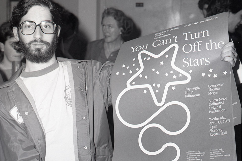 Disability Awareness Day 1983 photo showing man holding up poster for the You Can't Turn Off the Stars play