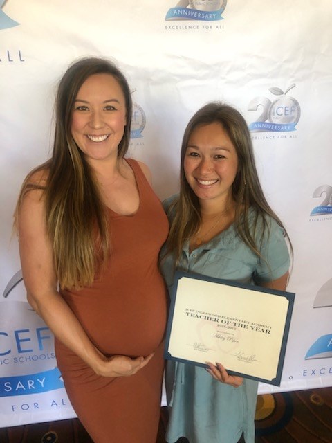 Ashley Peper and friend pose holding 'Teacher of the Year' certificate