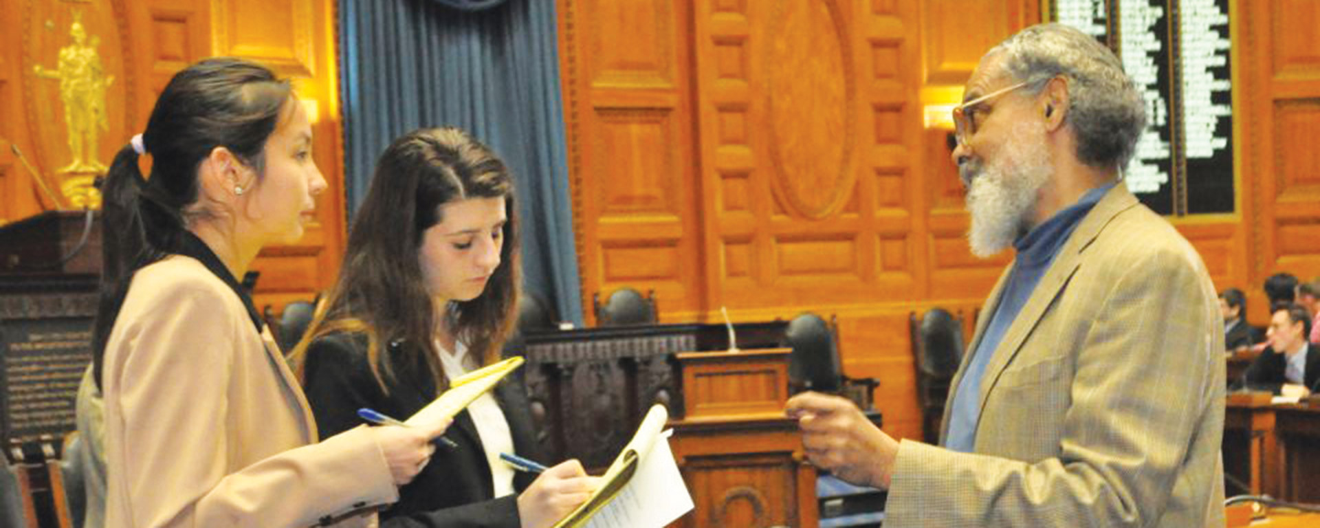 legislator speaks with two female students in state house