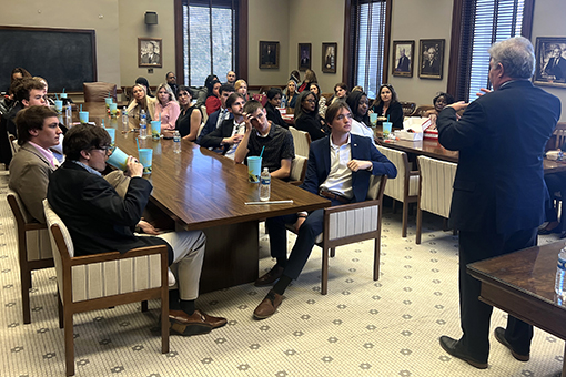 Professor standing in front of a class of students lecturing