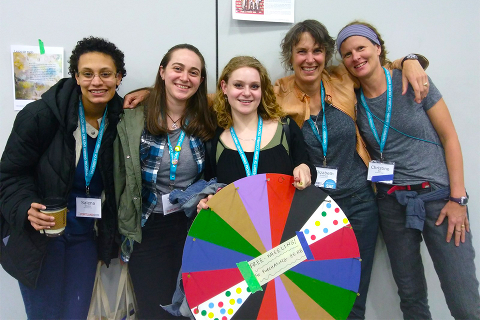 Salena Deane, Sarah Terrazano, and Rebecca Kahn standing with Professor Elizabeth Bradfield and writer Christine Byl at the AWP conference