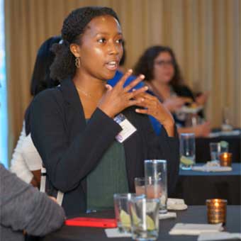 woman giving a speech at a table