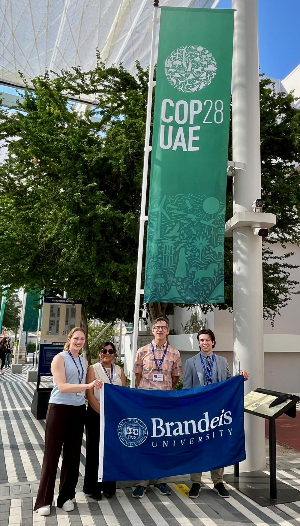 Students and Faculty Pose with Brandeis Banner in Dubai at COP28