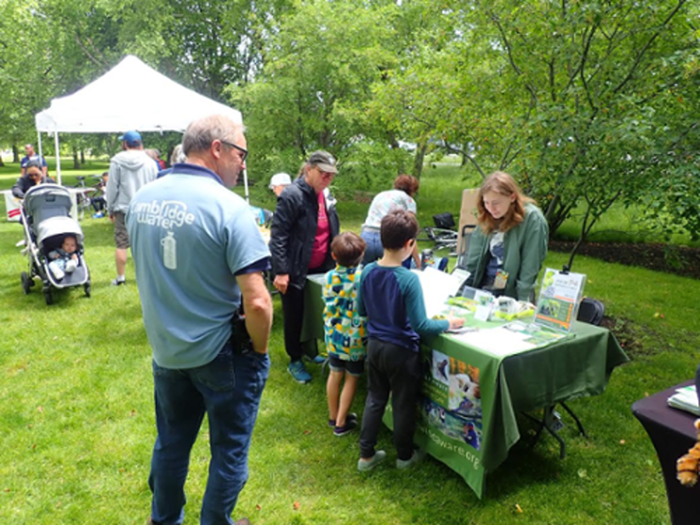 Madeline talks to two children at the EwA table outside