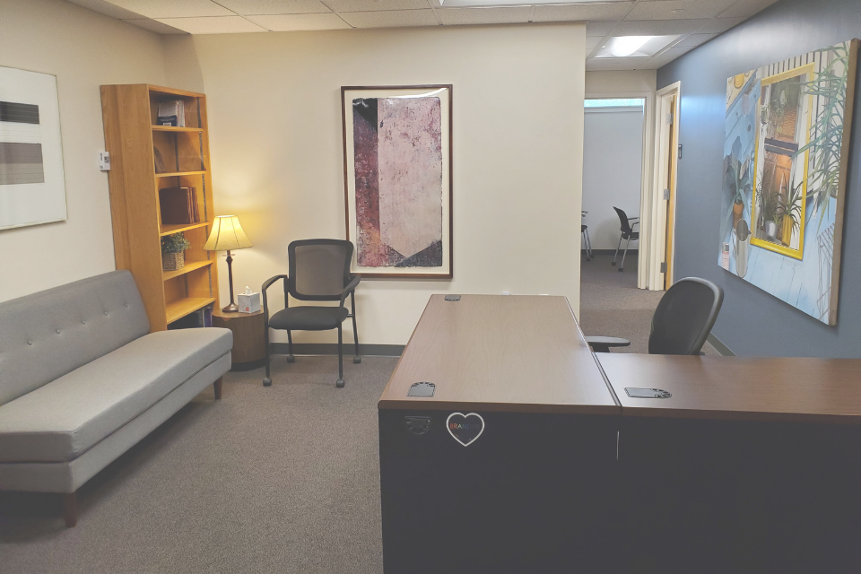 An office with a desk on the right and couch on the left