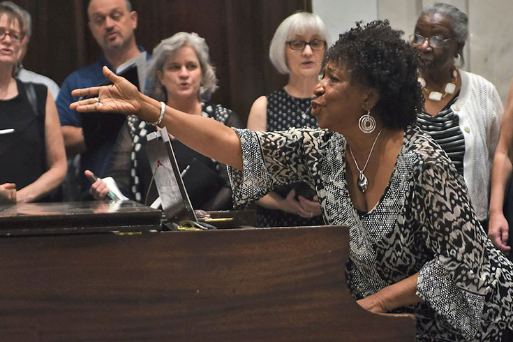 Jane Sapp standing up while playing the piano