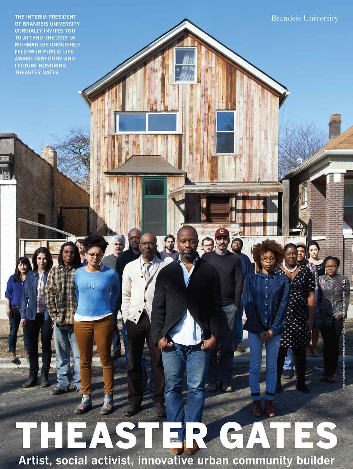 Theaster Gates stands with a large group behind him, standing in front of a house