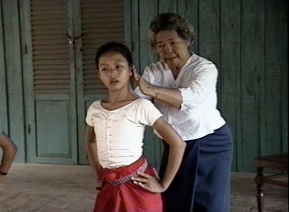 a woman teaching a younger woman a dance