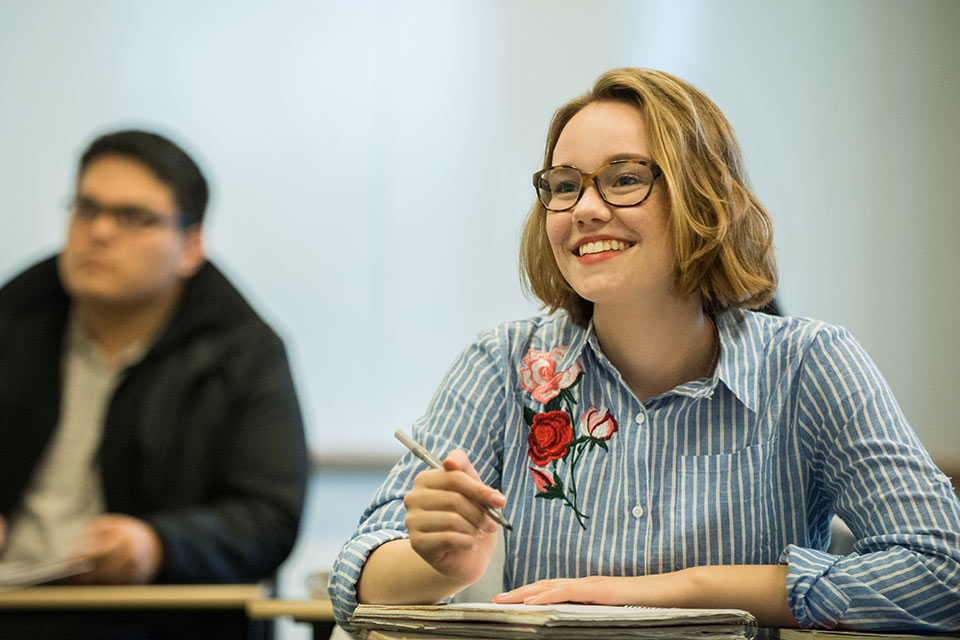 Female student seated at a desk in a classroom