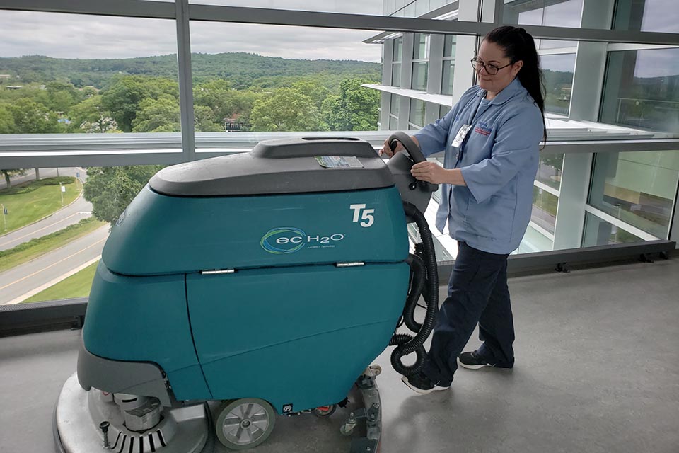 A person cleaning the floor with a floor machine