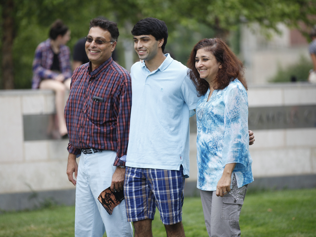 Parents and son walking across Brandeis' campus