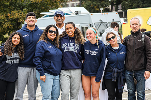 Group of people smiling in Brandeis sweatshirts and jackets