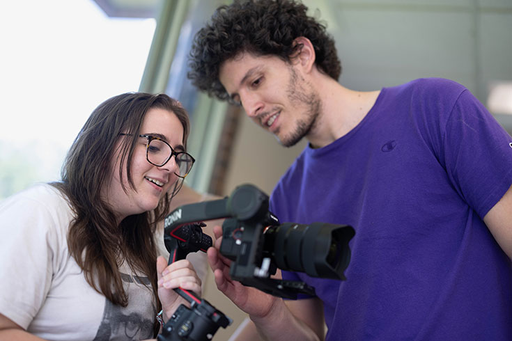 Professor Hernadi Ambrus looks at a camera with a student.