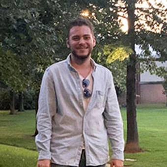 Rafi Levi standing on grass in light blue shirt.