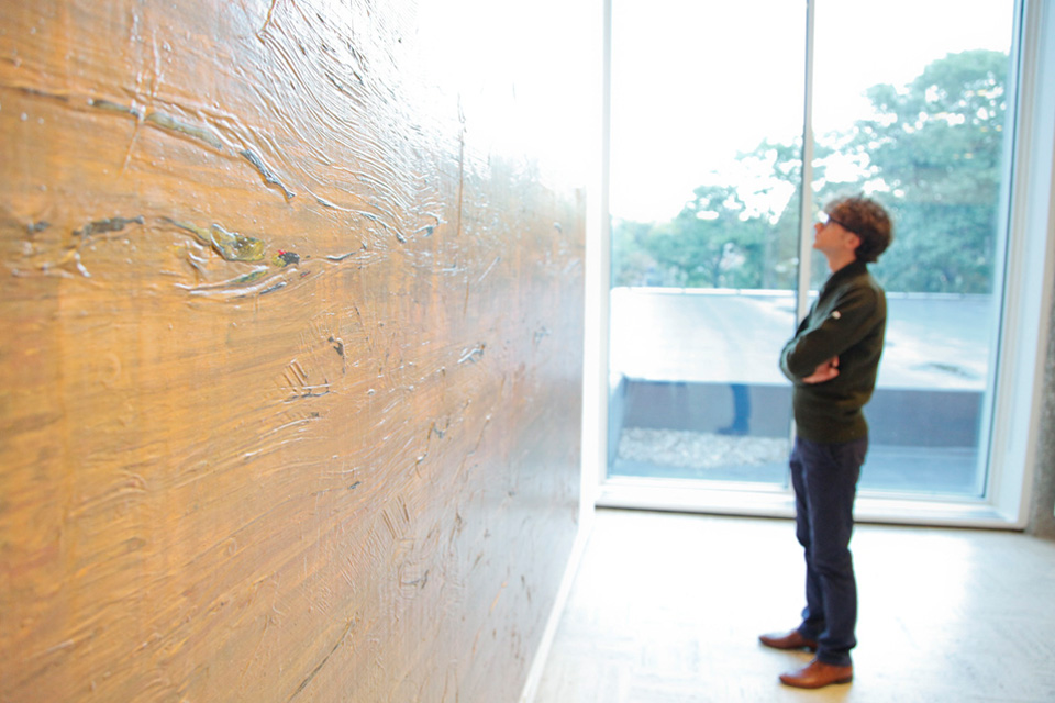 Man looking at gold wall painting