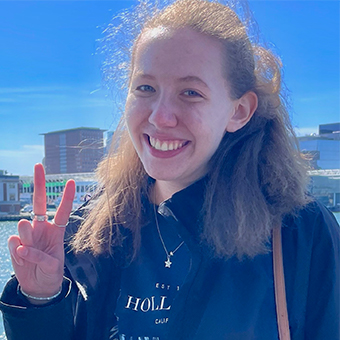 Portrait of Jennifer Podhorzer smiling and giving the peace sign