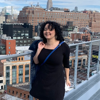 Portrait of Pilar Duvivier standing behind a buildings in New York City