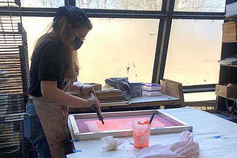 Side view of Young screenprinting in pink