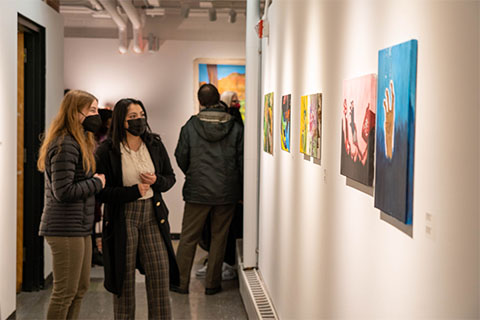 Two students standing and looking at the artwork on the wall