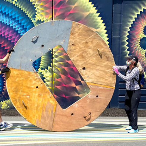 Large round sculpture made out of wood with a rectangle cut out of sculpture