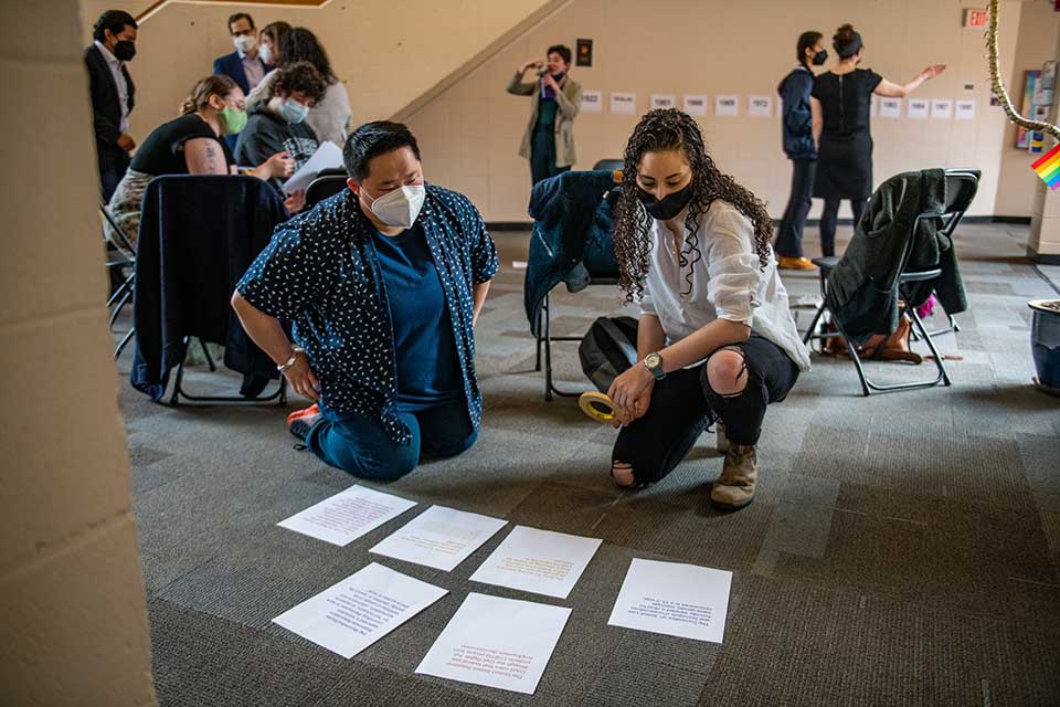 People looking at papers laying on the floor