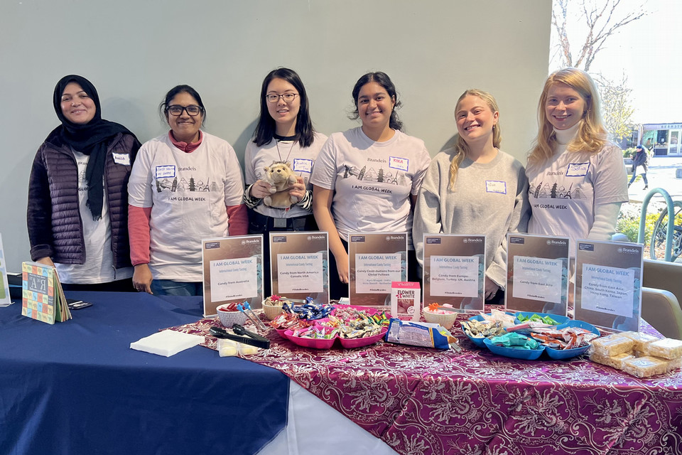 A group of Global Fellows in front of the I Am Global Week table