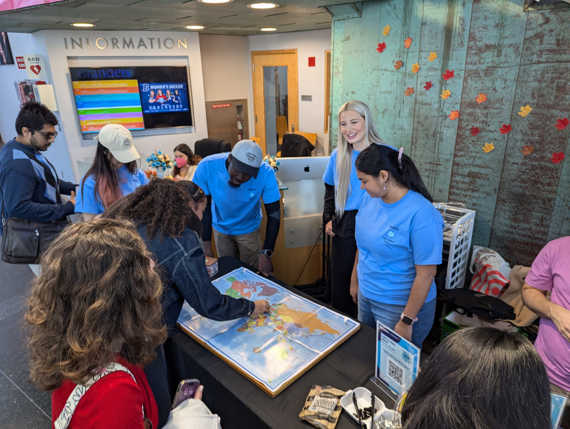 A group of Global Fellows standing at a table showing a map