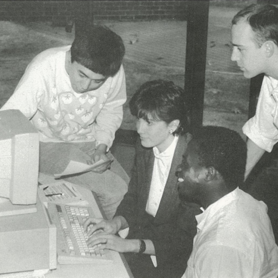 students gather around a computer