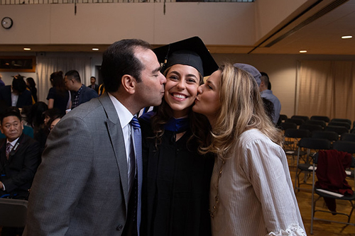 Students in caps and gowns smiling during graduation.