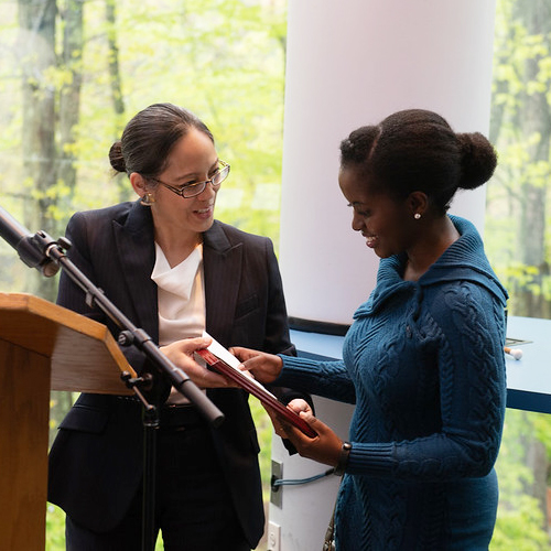 Student clapping while others receive an award.