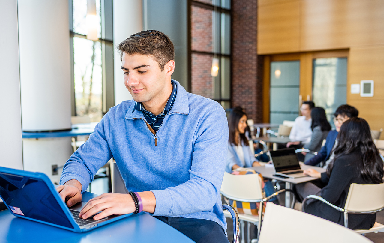 Student typing on laptop in World Court